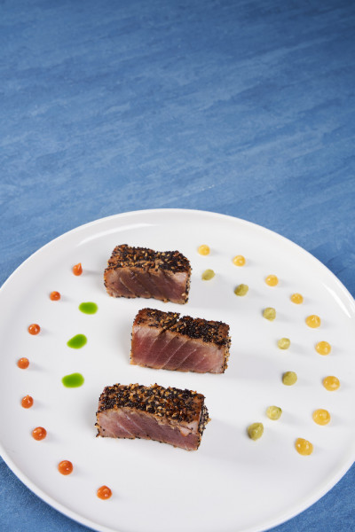 TUNA MARINATED IN SWEET AND SOUR SOY SAUCE, SAUTÉED WITH BLUE POPPY AND SESAME SEEDS AND SERVED WITH GUACAMOLE SAUCE